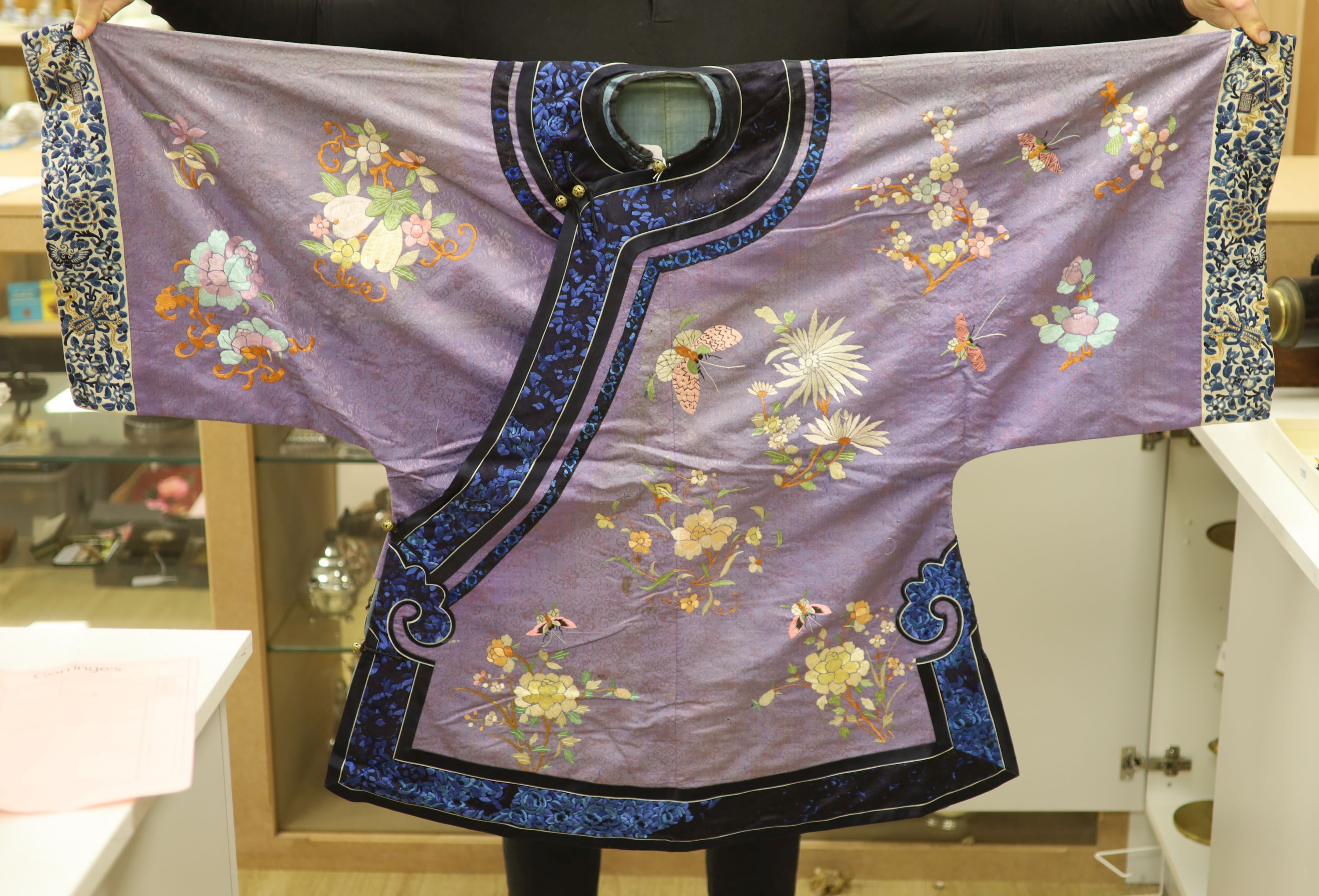 A Chinese lilac silk embroidered robe, early 20th century with multi-coloured embroidery and wide embroidered sleeve bands,